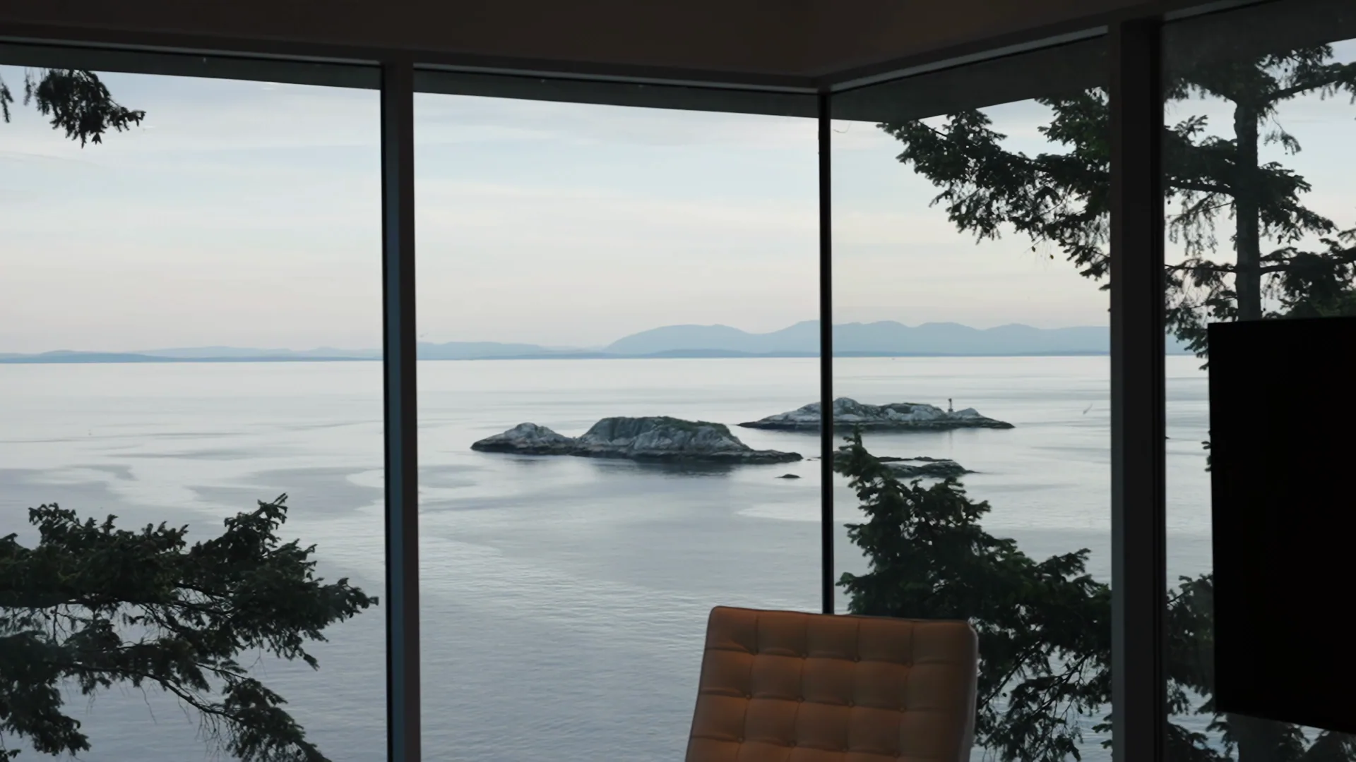 Oceanfront living room with floor-to-ceiling glass over Howe Sound, AFK Media
